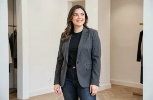 Femme morphologie poire portant un blazer structuré et un jean taille haute dans une boutique parisienne